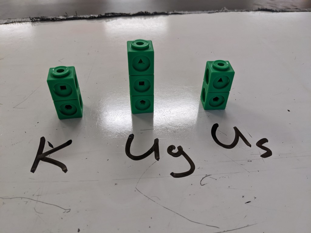 Cubes in three stacks on a whiteboard. Each stack is labeled with a type of energy.